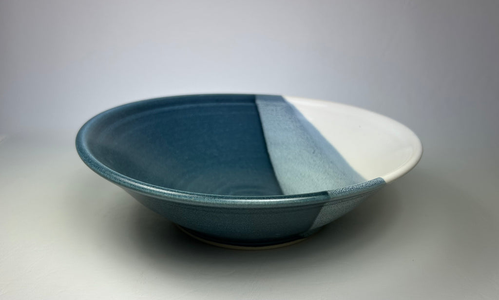 Low, wide serving bowl, blue and white with an overlap of the two glazes.